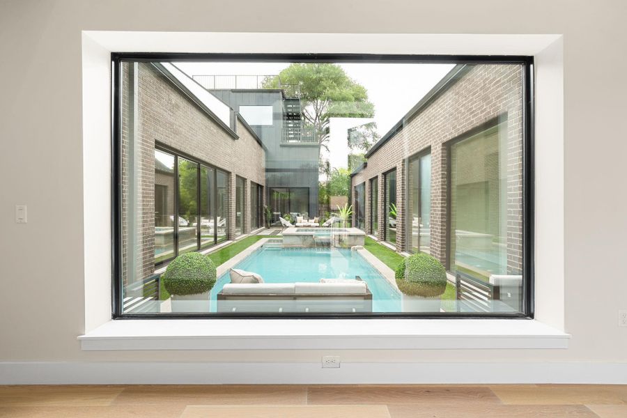 Expansive window offering a full exterior view of the private courtyard