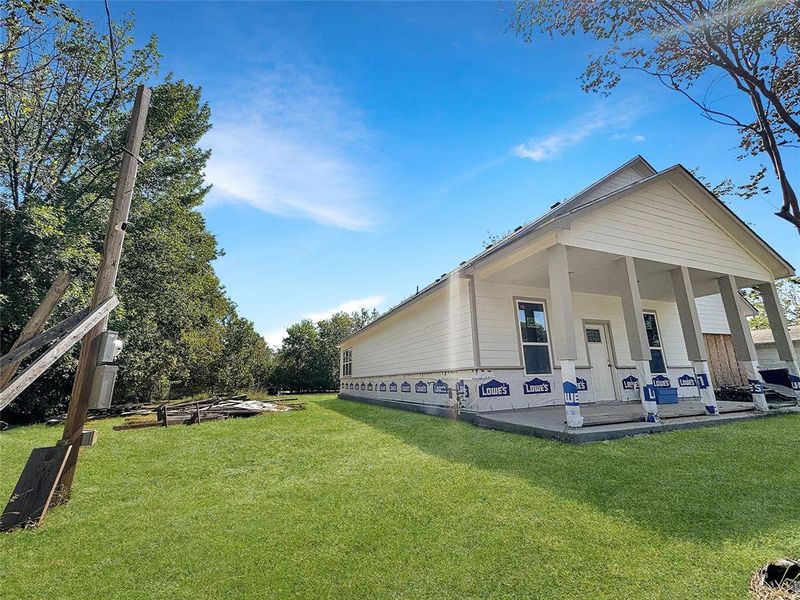 Rear view of property featuring a lawn and covered porch Rear view of property featuring a lawn and covered porch
