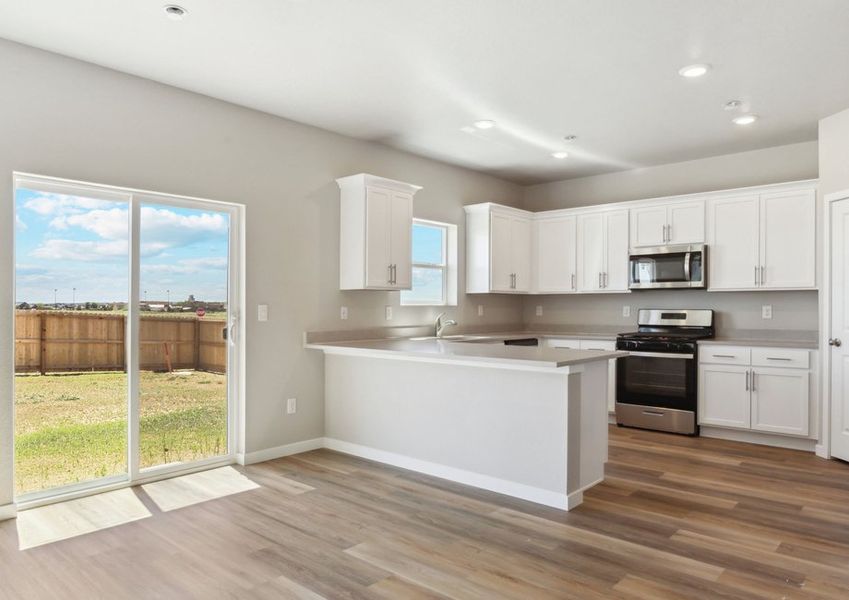 The kitchen has stainless steel appliances and white cabinets