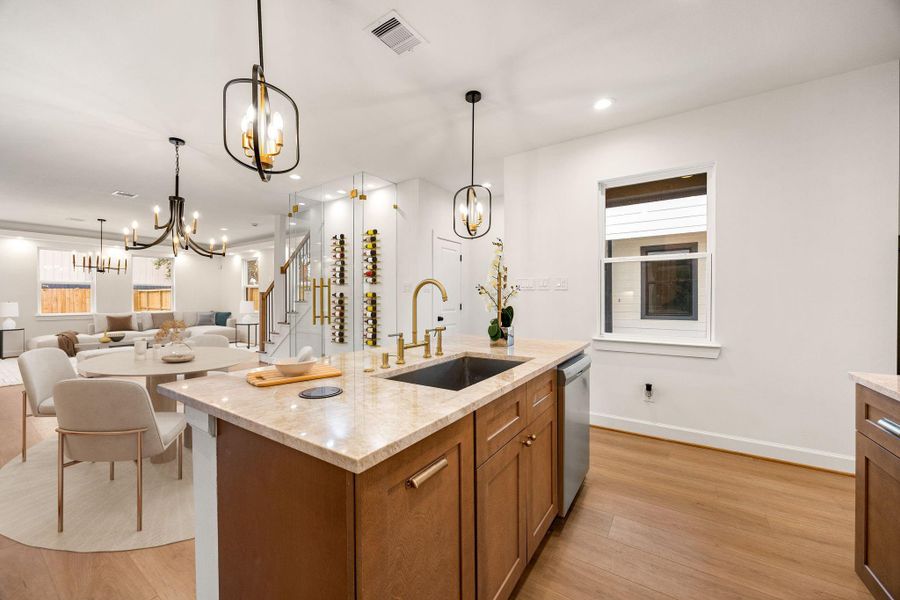 A beautifully designed kitchen showcases warm wood cabinetry, a spacious island with seating, and stylish pendant lighting, creating an ideal space for everyday living and effortless entertaining.