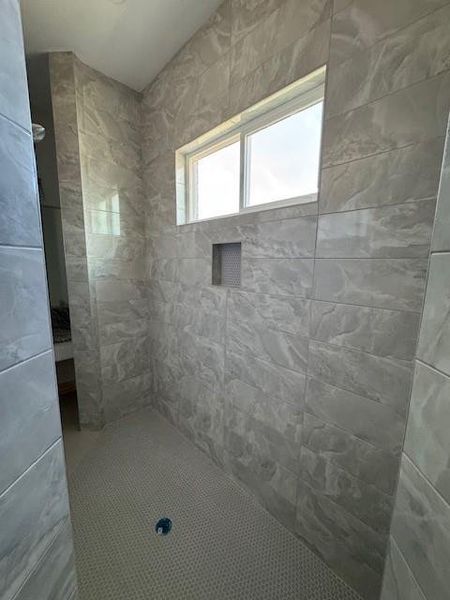 Full bath featuring a tile shower