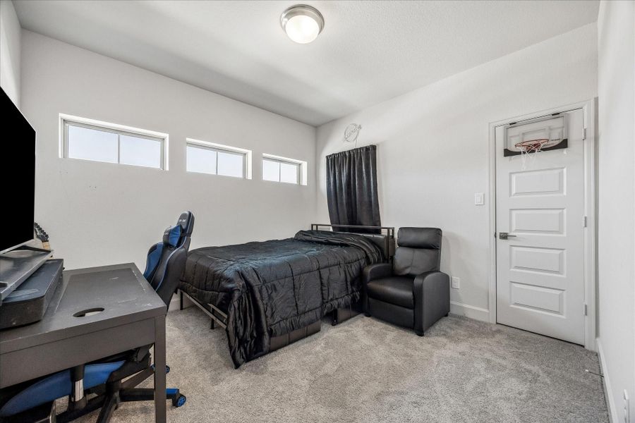 Spacious secondary bedroom with plush carpet, abundant natural light and a generous layout