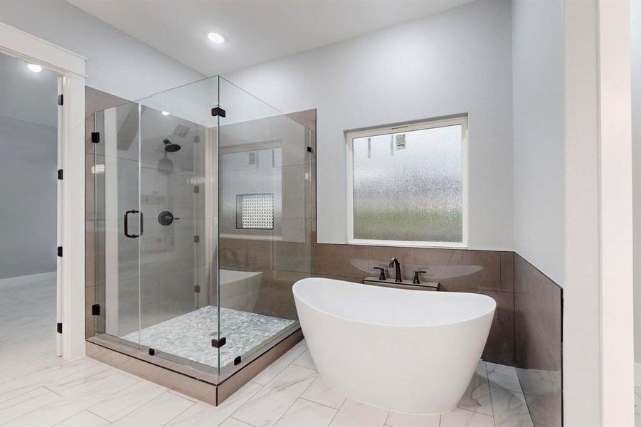 Bathroom featuring separate shower and tub and tile walls