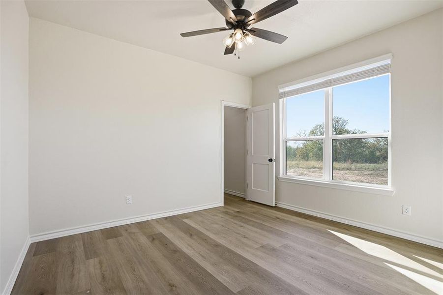 Unfurnished room with light wood-style flooring and a ceiling fan Unfurnished room with light wood-style flooring and a ceiling fan