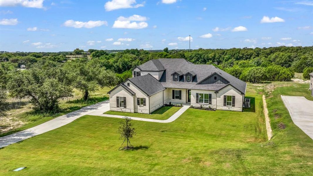 Front exterior of a new home in Woodland Lakes, Weatherford, TX, highlighting curb appeal (Image 1). Front exterior of a new home in Woodland Lakes, Weatherford, TX, highlighting curb appeal (Image 1).