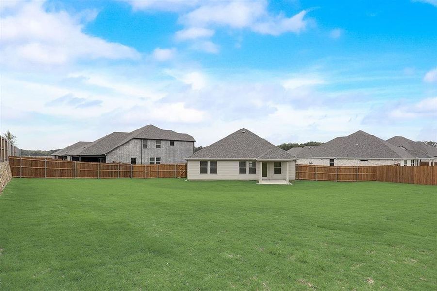 Rear view of house featuring a lawn and a patio area