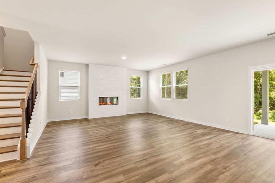 A room with a wood floor and a wood staircase. A room with a wood floor and a wood staircase.