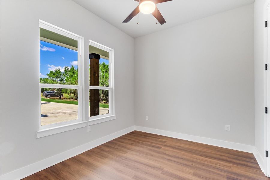Empty room with wood finished floors and a ceiling fan
