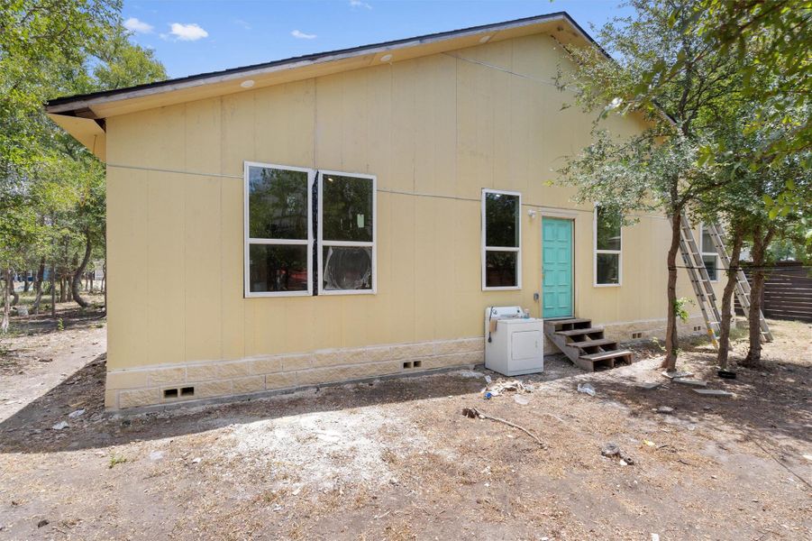 Rear view of house featuring crawl space, washer / clothes dryer, and entry steps Rear view of house featuring crawl space, washer / clothes dryer, and entry steps