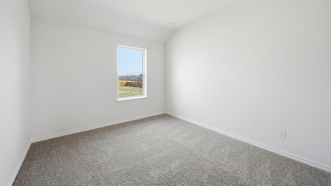 Spare room with lofted ceiling and carpet