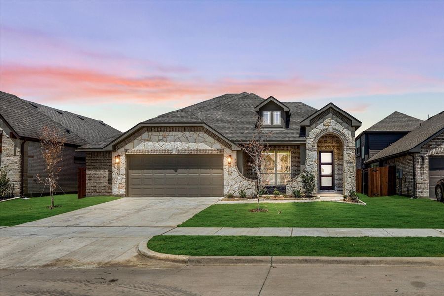 Single-story home with stone and brick exterior, two-car garage, and arched entry on a corner lot with green lawn. Single-story home with stone and brick exterior, two-car garage, and arched entry on a corner lot with green lawn.