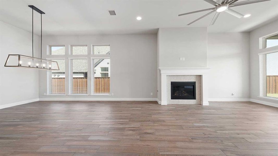 Unfurnished living room with light wood-type flooring and ceiling fan