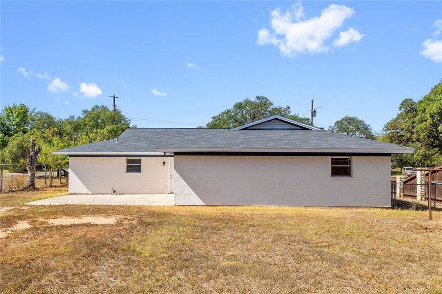 Rear view of property featuring brick siding and a patio