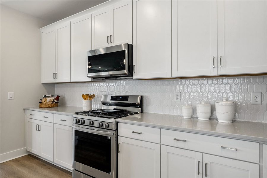 A contemporary kitchen features sleek white cabine A contemporary kitchen features sleek white cabine