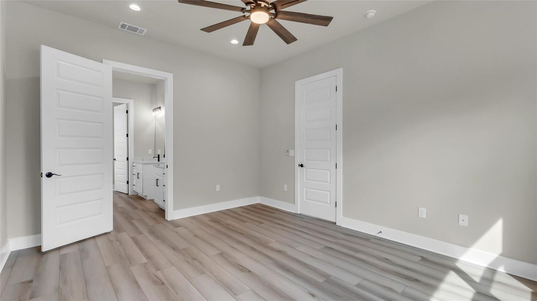 Unfurnished bedroom with ensuite bath, recessed lighting, light wood-style floors, and ceiling fan
