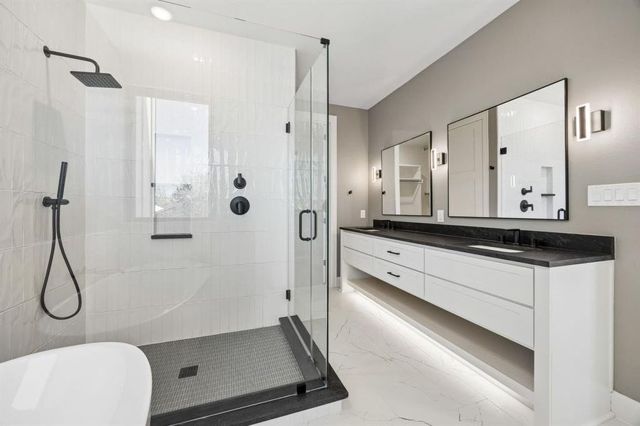 Bathroom with double vanity, a freestanding tub, a stall shower, and light marble finish floors Bathroom with double vanity, a freestanding tub, a stall shower, and light marble finish floors