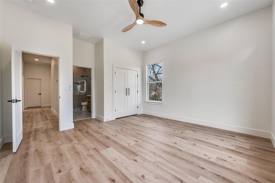 Unfurnished bedroom featuring light wood-style floors, ensuite bath, a closet, a ceiling fan, and recessed lighting