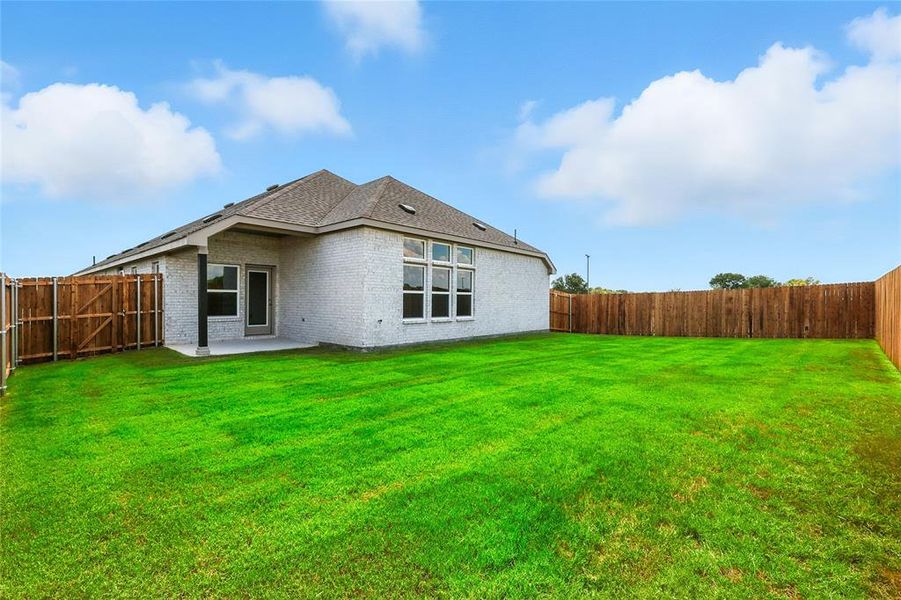 Rear view of house featuring a fenced backyard, a patio area, and brick siding Rear view of house featuring a fenced backyard, a patio area, and brick siding