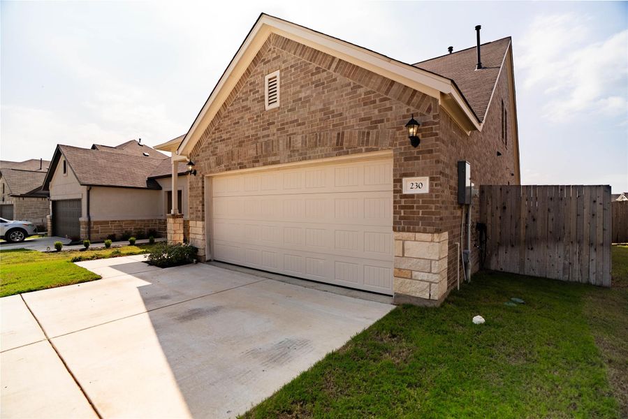 View of front of home featuring brick siding, driveway, an attached garage, and stone siding View of front of home featuring brick siding, driveway, an attached garage, and stone siding