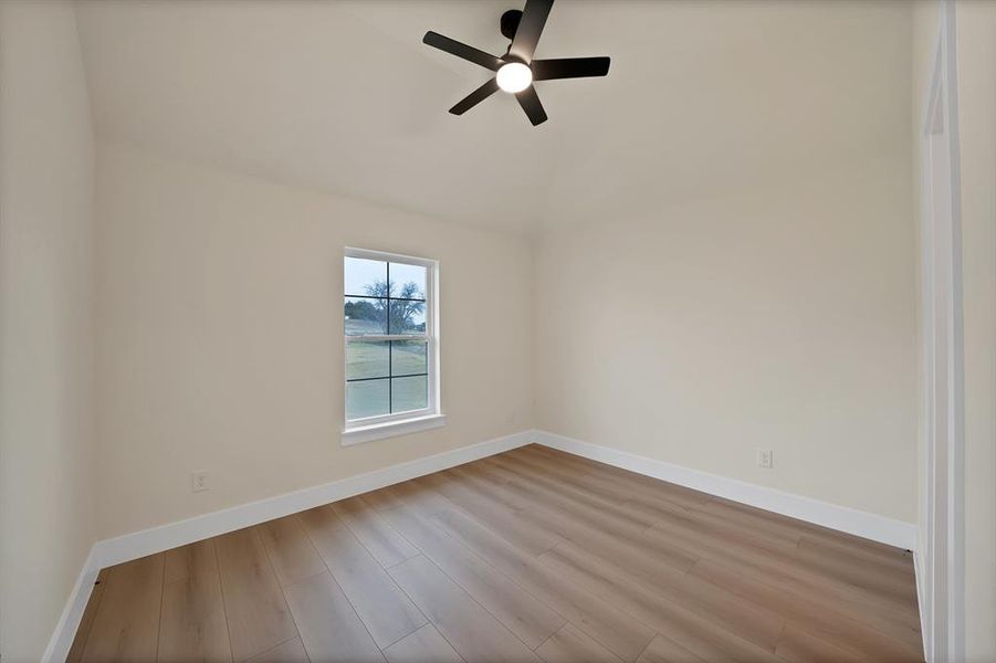Spare room with wood finished floors and a ceiling fan Spare room with wood finished floors and a ceiling fan
