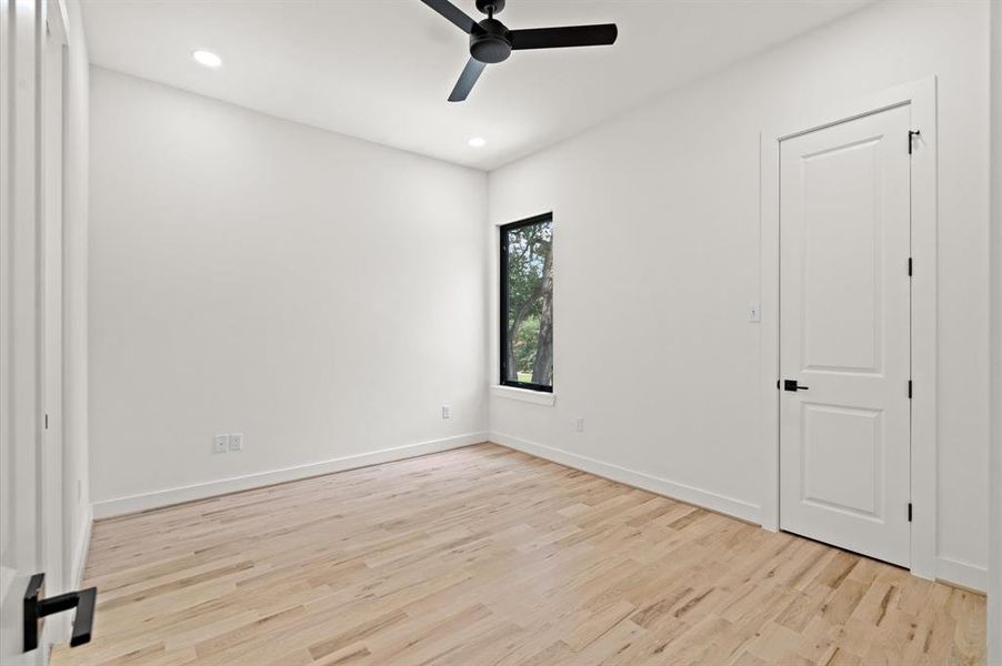 Secondary bedroom, each with recessed LED lighting, fan, and oak floors.