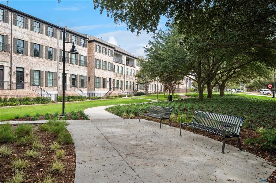 Community green space featuring a concrete pathway and two park benches Community green space featuring a concrete pathway and two park benches