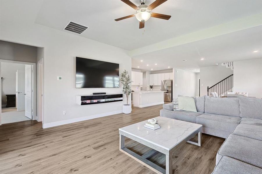 Living room with sink, light wood-type flooring, and ceiling fan