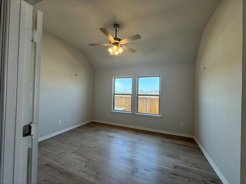 Unfurnished room with lofted ceiling, wood finished floors, and ceiling fan Unfurnished room with lofted ceiling, wood finished floors, and ceiling fan