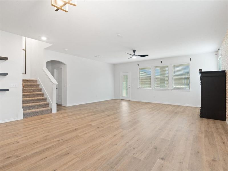 Unfurnished living room featuring ceiling fan and light wood-type flooring