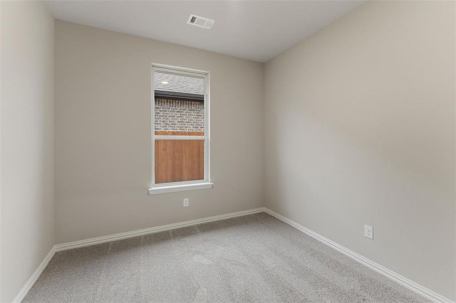 Neutral tone walls with white trim, light gray carpeting, and a double-pane window