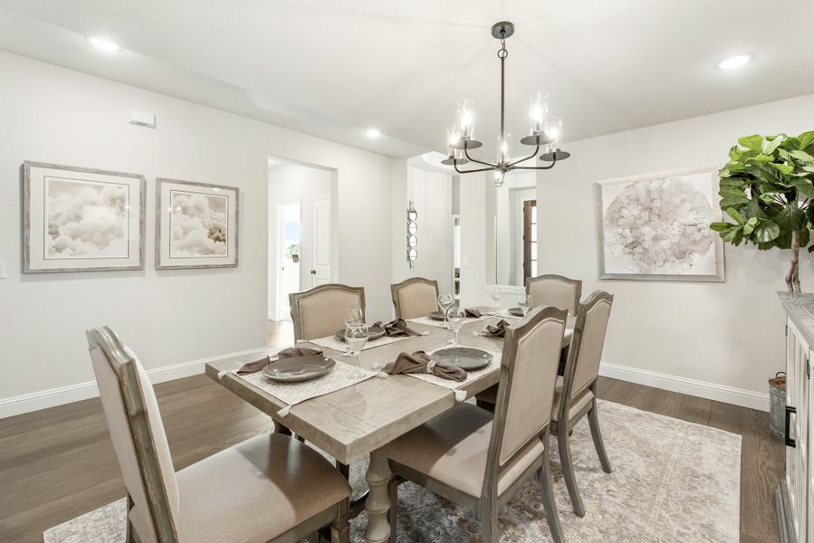 Formal dining room with six-chair table, chandelier, and hardwood floors in neutral tones