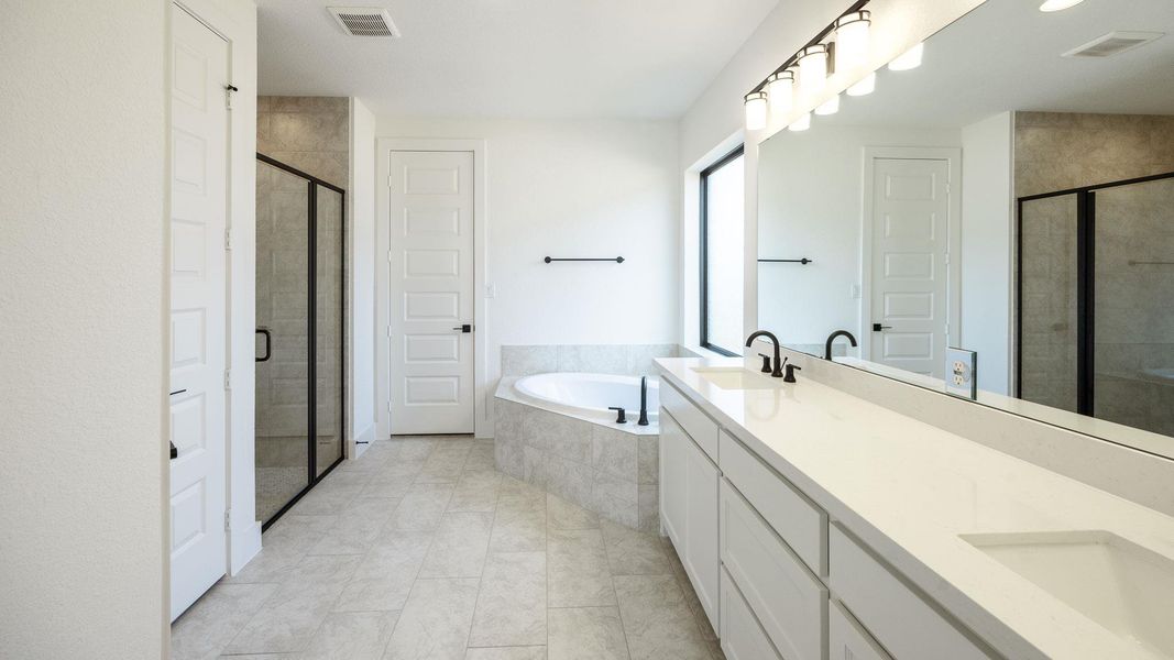 Bathroom with double vanity, a bath, a stall shower, light tile patterned floors, and recessed lighting