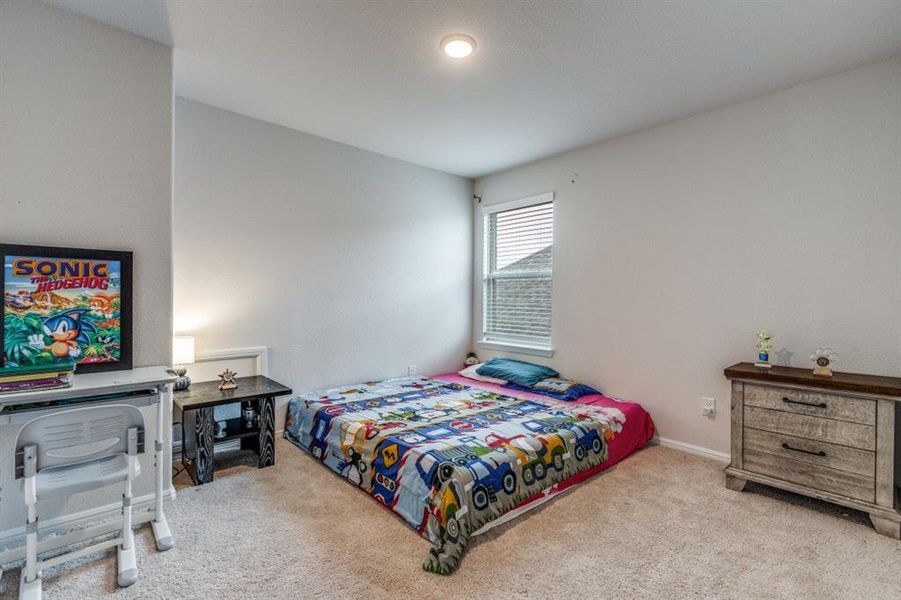 Bedroom with light colored carpet and baseboards