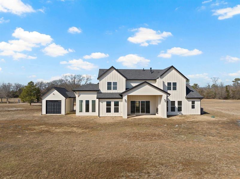 Back of property with board and batten siding and a shingled roof Back of property with board and batten siding and a shingled roof