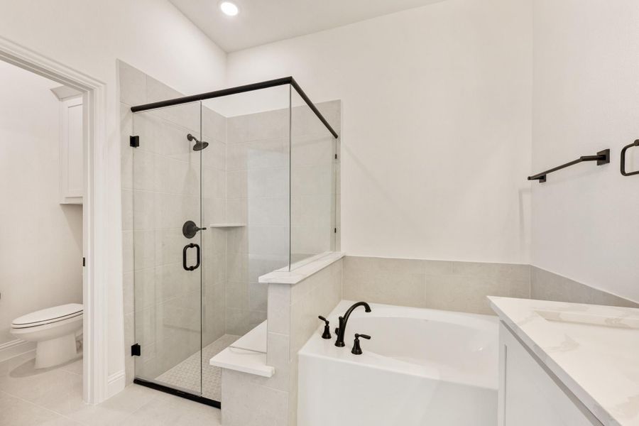 Bathroom with glass-enclosed shower, soaking tub, and white tile featuring black matte fixtures