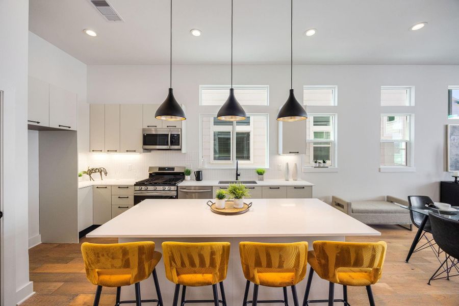 Sleek, modern kitchen with stainless steel appliances, elegant Italian cabinetry, soft closing cabinets/drawers, and a spacious island perfect for entertaining.