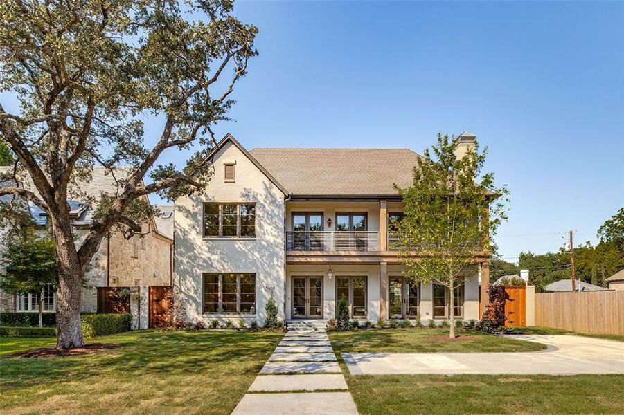 View of front of house featuring a balcony, a chimney, french doors, stucco siding, and roof with shingles View of front of house featuring a balcony, a chimney, french doors, stucco siding, and roof with shingles