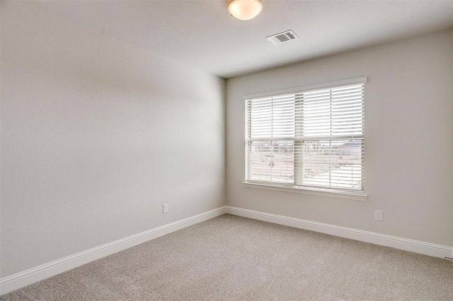 Empty room featuring light carpet, baseboards, and visible vents