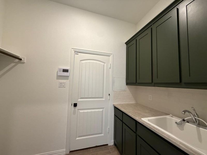 Laundry area featuring a sink and wood tiled floors