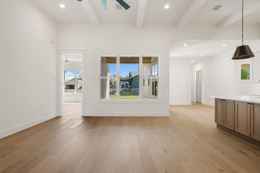 The property features light-colored wood flooring, white walls, and exposed ceiling beams