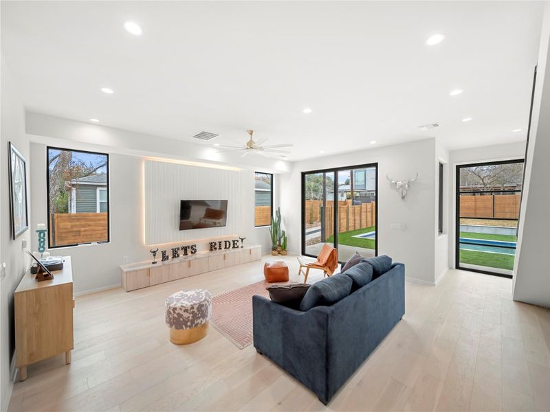Living room featuring ceiling fan, light wood-style flooring, and recessed lighting