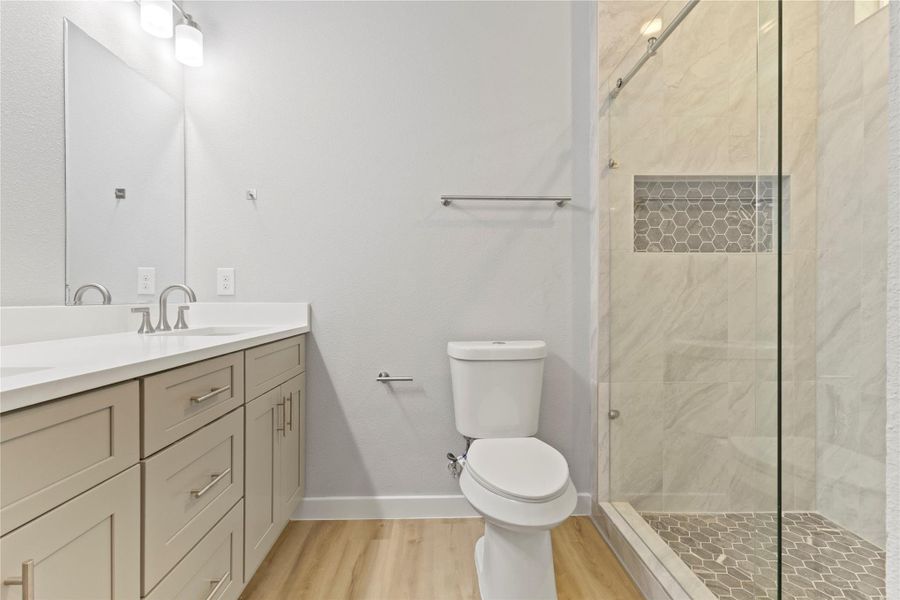 A stunning primary bathroom with a sleek double vanity, a luxurious shower, and radiant natural light. A stunning primary bathroom with a sleek double vanity, a luxurious shower, and radiant natural light.