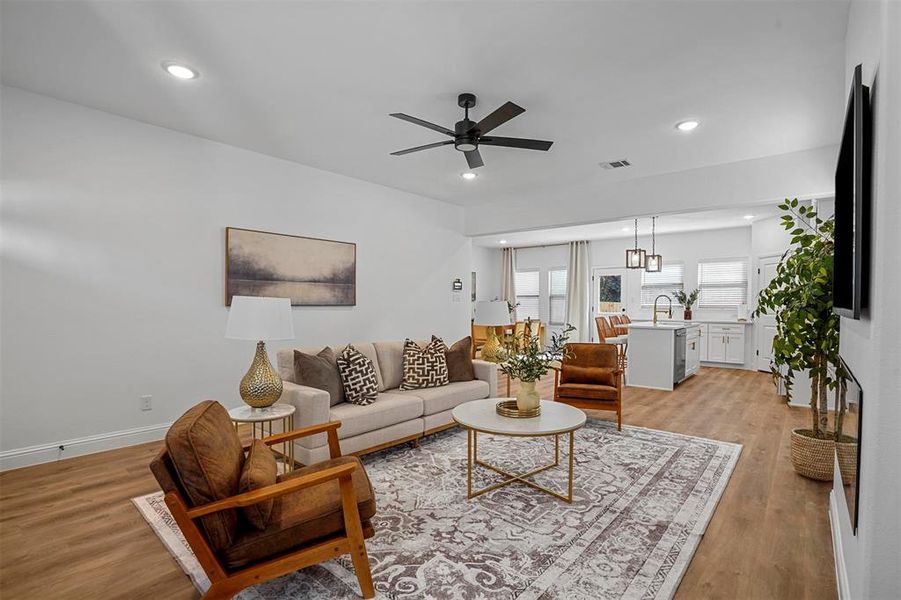 Living room with ceiling fan, sink, and light hardwood / wood-style flooring