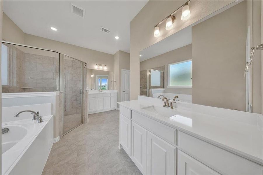 Full bathroom featuring a shower stall, two vanities, a garden tub, and recessed lighting Full bathroom featuring a shower stall, two vanities, a garden tub, and recessed lighting