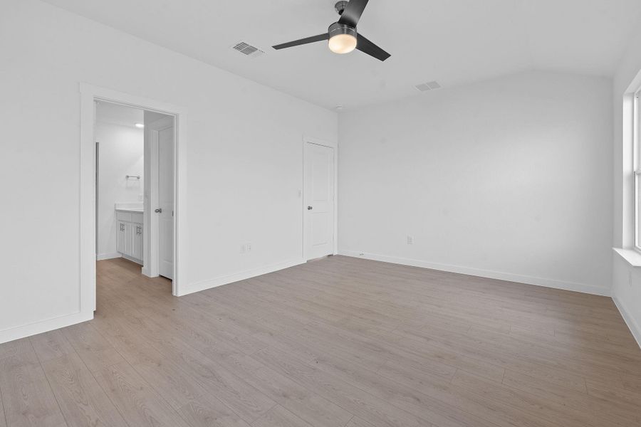 Unfurnished bedroom with light wood finished floors, ceiling fan, and lofted ceiling