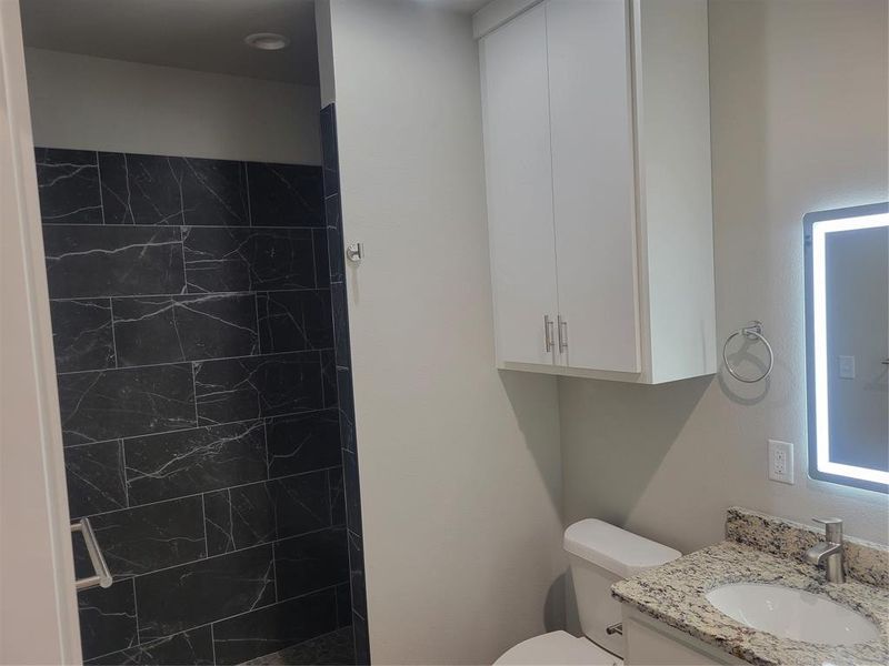 Bathroom featuring a vanity with granite countertop, undermount sink, and chrome faucet