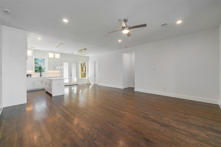 Unfurnished living room featuring dark hardwood / wood-style floors and ceiling fan