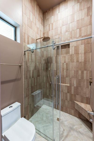 The beauty here is found in texture. Floor-to-ceiling tile, warm neutral tones, and understated fixtures come together to create a space that feels both modern and timeless. The result is an atmosphere that invites a slower start to the morning and a quieter end to the evening.