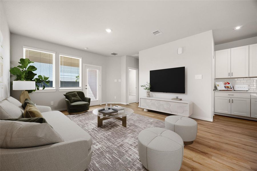 This bright and inviting living area offers an open layout with abundant natural light and a seamless flow to the kitchen. Featuring neutral tones, recessed lighting, and luxury vinyl plank flooring, this space combines comfort and modern style. The large windows and backyard access create the perfect setting for relaxing or entertaining.
