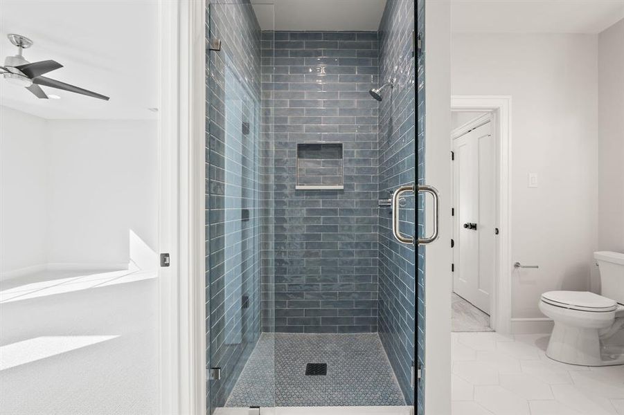 Full bathroom featuring a stall shower, light tile patterned flooring, and a ceiling fan Full bathroom featuring a stall shower, light tile patterned flooring, and a ceiling fan